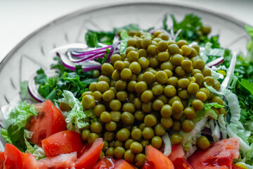 Fresh green peas in a summer vegetable salad. Healthy eating.