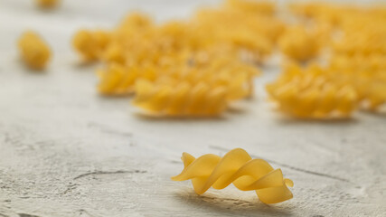 Yellow fusilli pasta close up on a blurred background. Italian food.