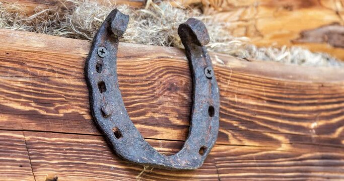 Rusty horseshoe hanging on the wall of a wooden house