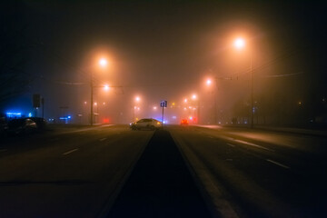 Empty street at foggy night in a city