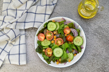 vegetable salad with olive oil and napkin on the concrete background. horizontal view. Vegetarian diet.