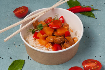 rice with chicken and vegetables in sweet and sour sauce in a craft bowl. concept: food delivery