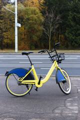 Naklejka premium Yellow rental bike stands near the road