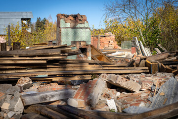 Fototapeta premium Photo of ruin of an old red brick building against the background of garbage, rubbish and junk on the street