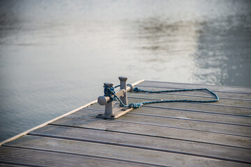 Naklejka premium Double cross bollard or bitteng with a tied rope on the dock. towing mooring gear