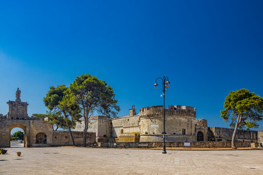 The small fortified village of Acaya, Lecce, Salento, Puglia, Italy. The large stone-paved square. The castle with the towers and the entrance door, with the large arch and the stone statue.