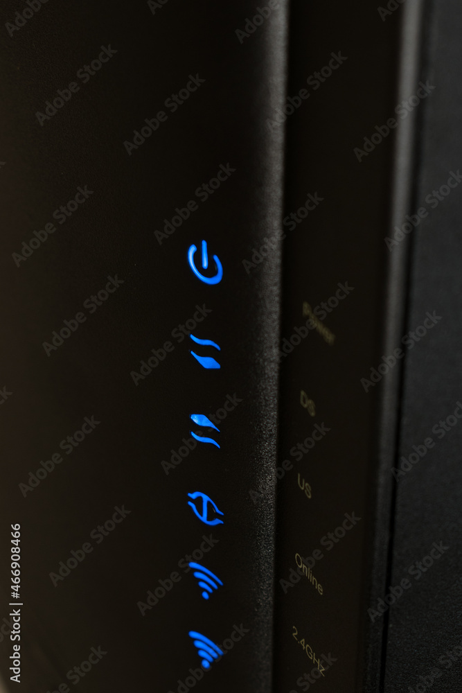 Poster vertical shot of a lack internet modem with blue light buttons of power and wifi symbol