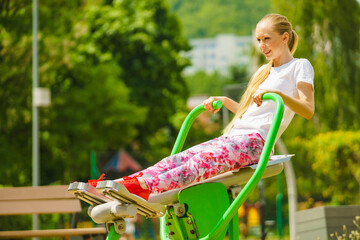 Girl doing legs exercise at outdoor gym area