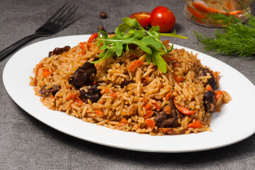 pilaf with beef on a white plate in a restaurant