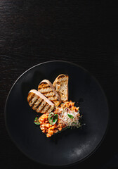 Raw salmon tartare with sliced bread on black plate