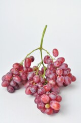 bunch of fresh seedless red grapes isolated on white background.