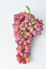 bunch of fresh seedless red grapes isolated on white background.