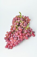 bunch of fresh seedless red grapes isolated on white background.