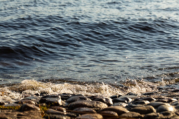 Water waves on the strip of the embankment of the city. Surf of water near the shore