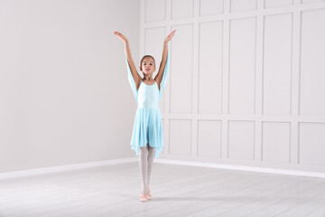 Fototapeta na wymiar Beautifully dressed little ballerina dancing in studio. Space for text
