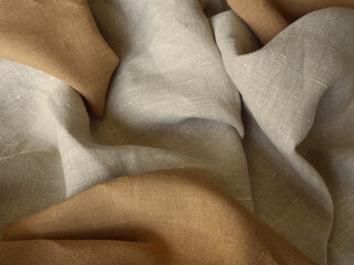 Beige and brown linen fabric. Woven  texture background. Earth tone color textile drapery for sewing, fashion and cloth. Cotton and linen natural textile surface. Earth tone colors draped background. 