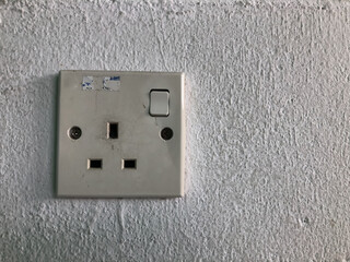 Electric plug socket on white wall. Selective focus.