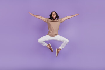 Full size photo of young cheerful latin man good mood jump up carefree isolated on purple color background