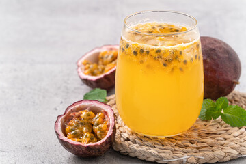 Delicious juicy passion fruit with sparkling juice on gray table background.