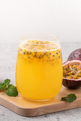 Delicious juicy passion fruit with sparkling juice on gray table background.