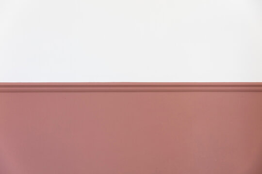 Modern interior with a painted victorian dado rail in pink and blank white wall above