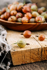 Red gooseberries on a wooden table.