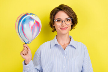 Photo of young woman happy positive smile hold air balloons decoration party isolated over yellow color background