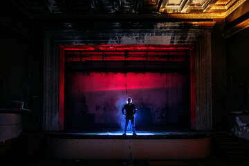 Man on the stage of creepy abandoned theater