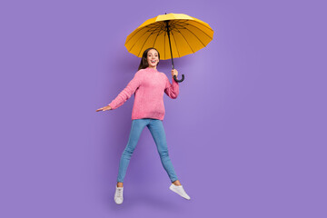 Full size photo of impressed mature lady jump with umbrella wear pullover jeans footwear isolated...