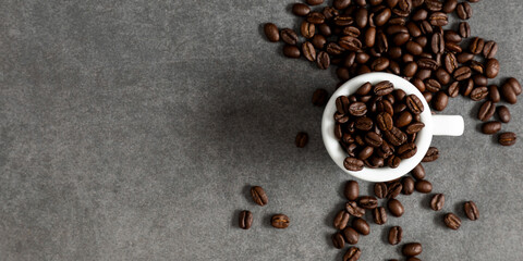 Cup coffee and roasted coffee beans on gray stone background. Flat lay, top view, copy space