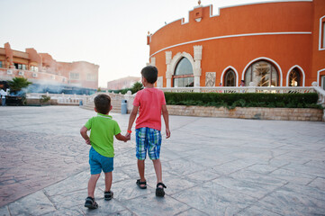 Two brothers holding hands on egyptian resort.