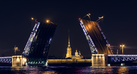 Fototapeta na wymiar Classic symbol of Bridges in St. Petersburg. Night View of the Peter and Paul Fortress through the Palace bridge