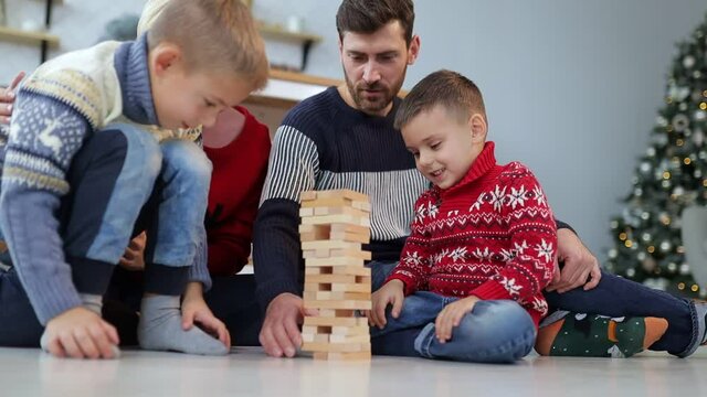 Happy family. mom, woman and children play a game. make a tower from wooden blocks. Teamwork in family relationships