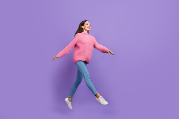 Fototapeta na wymiar Full length photo of funny young lady run wear pullover jeans sneakers isolated on purple background
