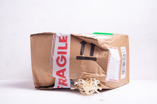 Broken cardboard box, fragille marked parcel