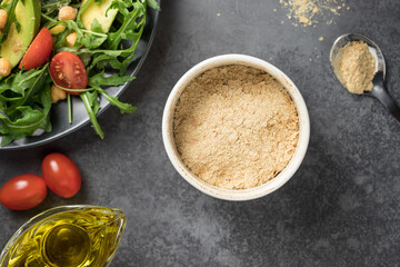 Nutritional yeast superfood in ceramic bowl. Plant-based food concept. closeup