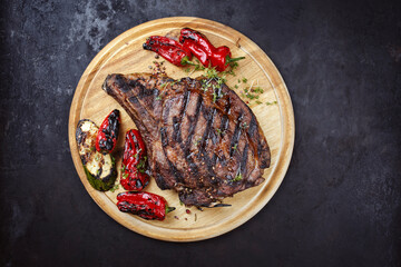 Traditional barbecue dry aged wagyu cote de boeuf beef steaks with zucchini and chili served as top view on a wooden board with copy space