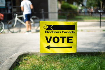 A yellow election sign directs people where to cast their voting ballot
