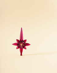 Christmas pink star with golden sparkles against champagne background. Minimal New Year and winter holidays layout with natural light.