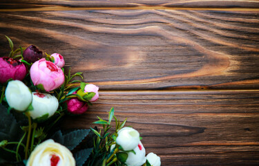 Flowers Rununculus on a wooden brown background in spring. Copy space