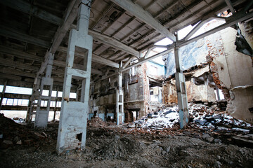 Abandoned ruined large industrial hall with garbage waiting for demolition