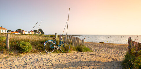 Vieux vélo bleu sur une plage de l'île de Noirmoutier en Vendée pendant les vacances en France.