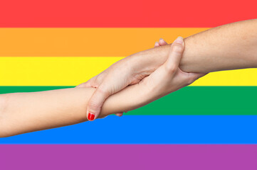 Woman's hands holding on to union symbol with gay pride flag in the background