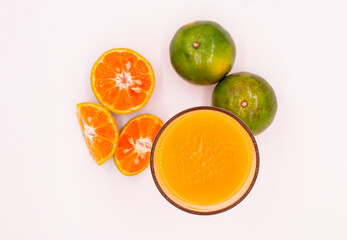 1 full glass of orange juice with 2 orange and sliced fruits isolated on white background. 100 % Orange juice. on top view.
