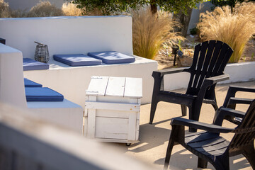 Salon de jardin au soleil sur une terrasse en été.