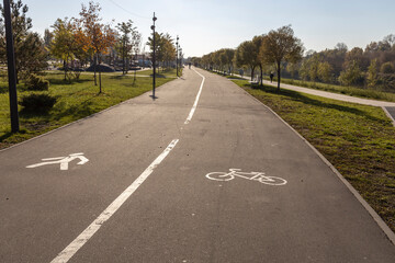 White road markings for pedestrians and cyclists.The walking and cycling paths in the park are separated from each other. Infrastructure for walking and physical activity in the park