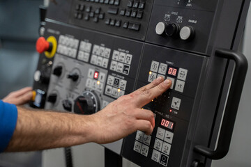 man using the controls of a CNC Lathe