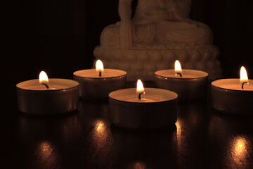 Fototapeta na wymiar Tea light candles in the dark.