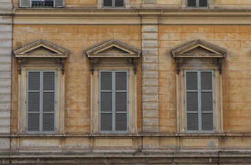 Traditional Building Facade Detail with Windows and Grey Shutters in Rome, Italy