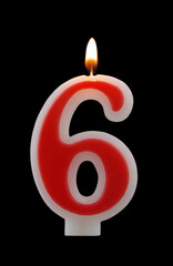 Red birthday candle isolated on black background, number 6